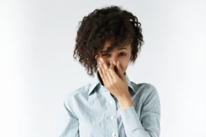 Woman holding her nose because of bad smell